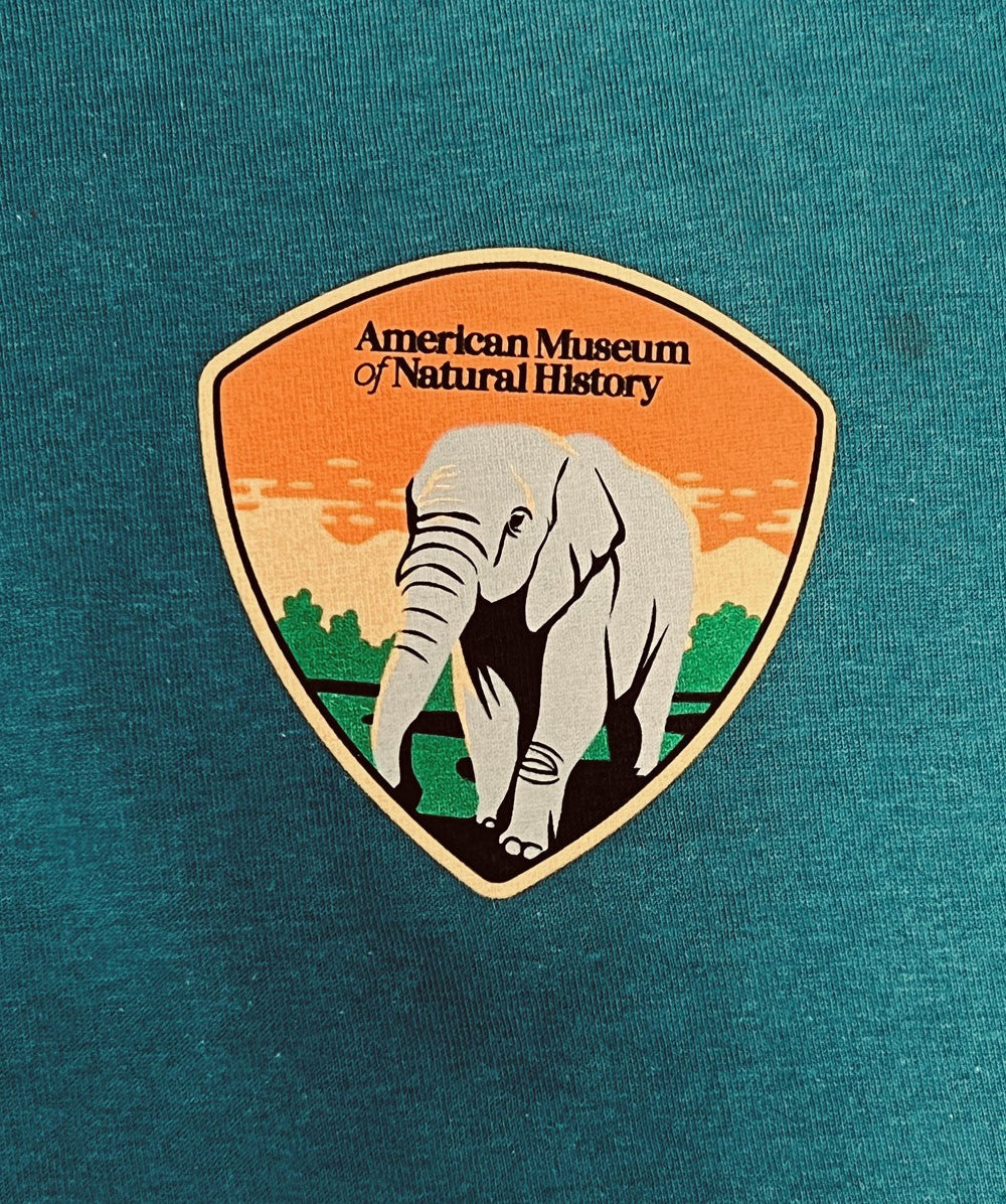 Adult AMNH Teal Blue Elephant Shield T-Shirt closeup